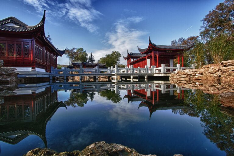 japanese pond with traditional houses and a blue sky
